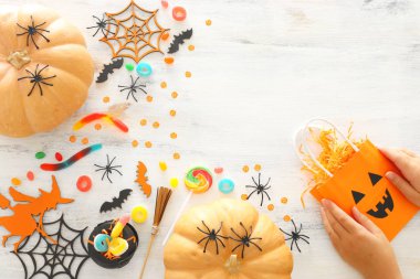 Cadılar Bayramı tatil görüntü. Kabaklar, yarasalar, davranır ve beyaz ahşap arka plan üzerinde sevimli cadı. üst görünüm, düz yatıyordu