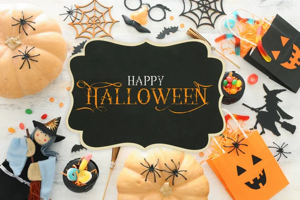 Cadılar Bayramı tatil görüntü. Kabaklar, yarasalar, davranır ve beyaz ahşap arka plan üzerinde sevimli cadı. üst görünüm, düz yatıyordu