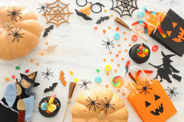 Cadılar Bayramı tatil görüntü. Kabaklar, yarasalar, davranır ve beyaz ahşap arka plan üzerinde sevimli cadı. üst görünüm, düz yatıyordu