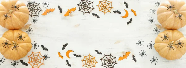 holidays Halloween image. pumpkin, bats and spiders over wooden white table. top view, flat lay. banner