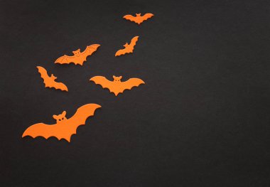 Cadılar bayramı konsepti. Siyah arka planda turuncu yarasalar. Üst manzara, düz uzanma
