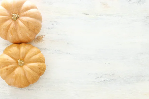 holidays Halloween image. pumpkins over wooden white table. top view, flat lay