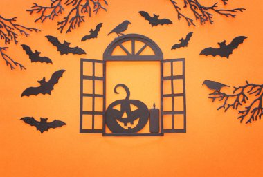 holidays concept of Halloween . open window with pumpkin in the woods and bats over orange background. Top view, flat lay