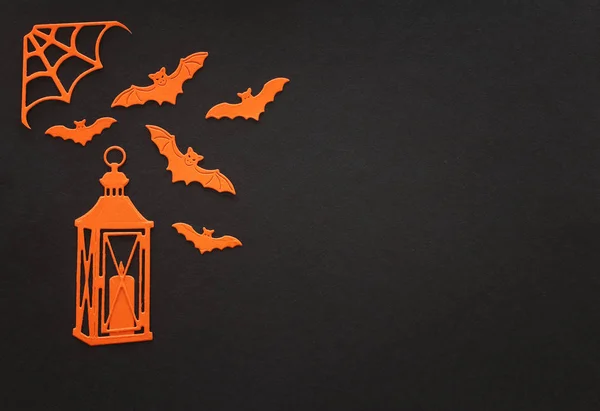 Feestdagen concept van Halloween. Oranje vleermuizen en lantaarn met kaars over zwarte achtergrond. Bovenaanzicht, vlak lay — Stockfoto