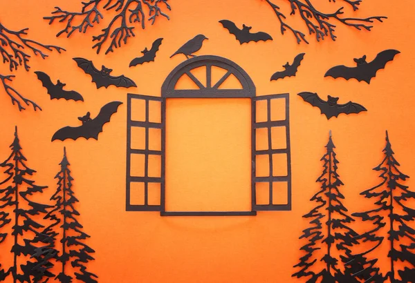 Concetto di festa di Halloween. finestra aperta nel bosco e pipistrelli su sfondo arancione. Vista dall'alto, piatta — Foto Stock