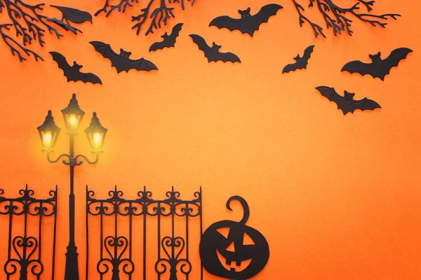 Helgdagar Halloween koncept. hemsökt gränd med träd och fladdermöss över orange bakgrund. Ovanifrån, platt ligg — Stockfoto
