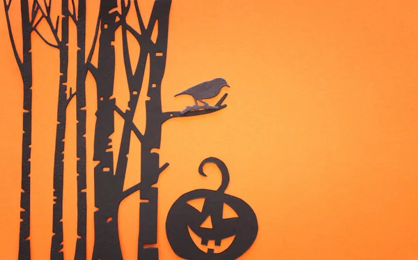 Concetto di festa di Halloween. Foresta infestata e zucca su sfondo arancione. Vista dall'alto, piatta — Foto Stock