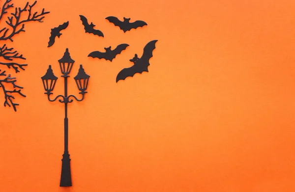 명절 할로윈 컨셉이야. 빈티지 길거리 램프와 박쥐들 이 주황색 배경 위에 있습니다. 위에서 본 전경, 평평 한 면 — 스톡 사진
