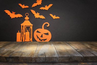 Cadılar bayramı konsepti. Yarasaların önündeki boş köy masası, balkabağı ve fener arka planı. Ürün görüntüleme kurgusu için hazır