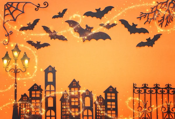Ünnepek Halloween koncepció. kísértetjárta sikátor vintage kerítéssel, utcai lámpafákkal és denevérekkel narancssárga háttér felett. Felülnézet, lapos fektetés — Stock Fotó