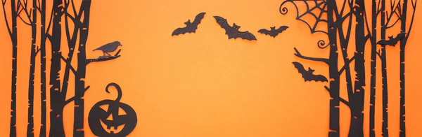 Concetto di festa di Halloween. Foresta infestata, zucca e pipistrelli neri su sfondo arancione. Vista dall'alto, piatta — Foto Stock
