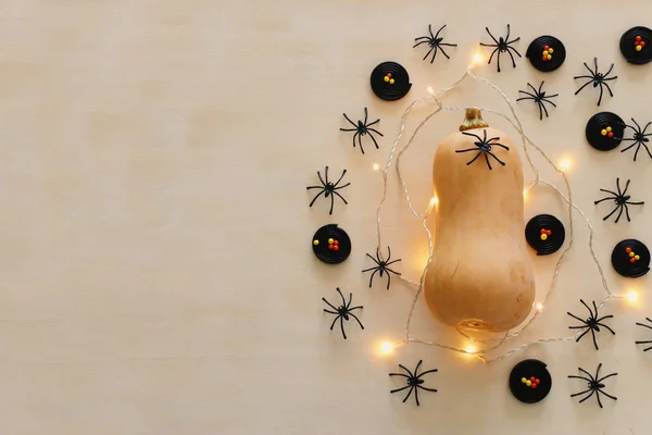 Holidays Halloween image. pumpkin and gold garlan lights over wooden white table. top view, flat lay — Stock Photo, Image
