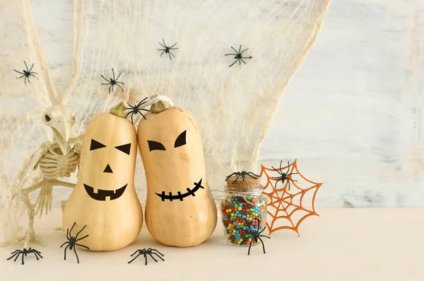 Vakantie foto van Halloween. Pompoenen, vleermuizen, traktaties over witte houten tafel — Stockfoto