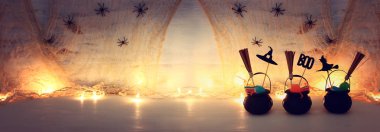 Cadılar Bayramı tatil görüntü. Witcher kazanı, süpürge, şekerler ve örümcekler beyaz ahşap masa üzerinde