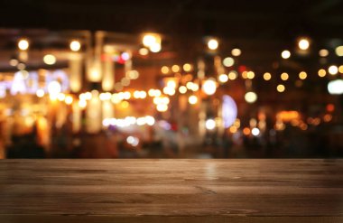 Soyut bulanık restoran ışıklarının önündeki ahşap masanın arkaplan resmi
