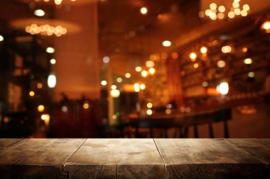 Soyut bulanık restoran ışıklarının önündeki ahşap masanın arkaplan resmi