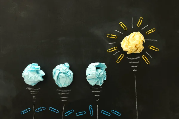 Education concept image. Creative idea and innovation. Crumpled paper as light bulb metaphor over blackboard — Stock Photo, Image