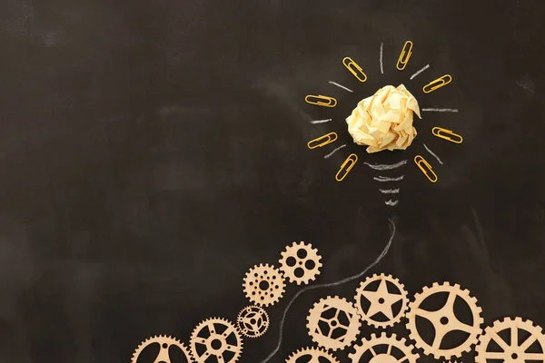 Education concept image. Creative idea and innovation. Crumpled paper as light bulb metaphor over blackboard — Stock Photo, Image