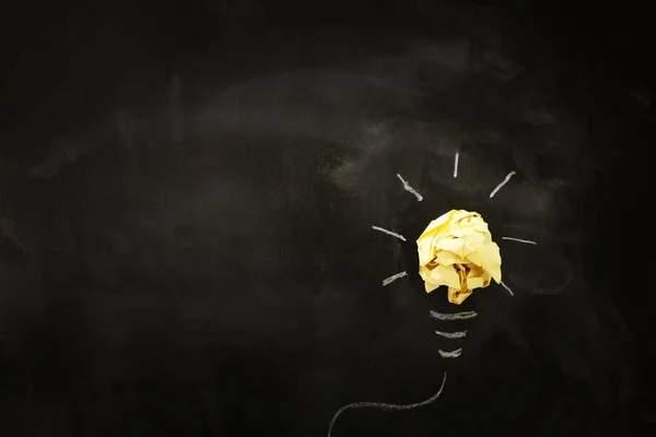 Imagem de conceito de educação. Ideia criativa e inovação. Papel enrugado como metáfora de lâmpada sobre quadro negro — Fotografia de Stock