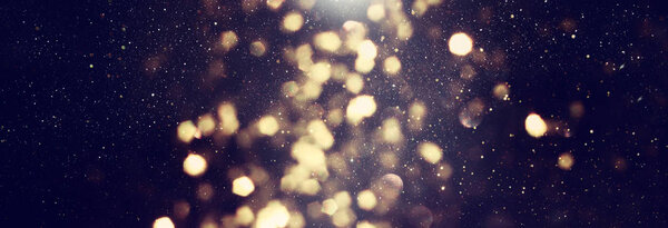 Background of abstract glitter lights. gold and black. de focused. banner