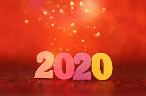 Sváteční obrázek konceptu nového roku 2020. Dřevěné číslo a šumivé pozadí — Stock fotografie