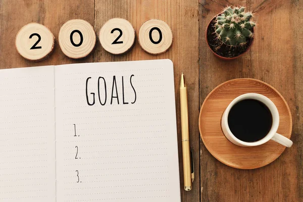 Zakelijk concept van top view 2020 doelen lijst met notebook, kopje koffie over houten bureau — Stockfoto