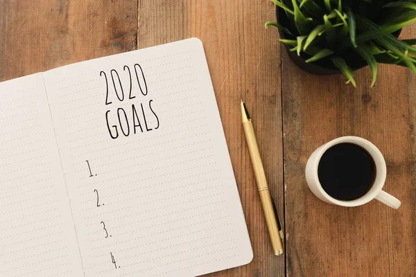 Business concept of top view 2020 goals list with notebook, cup of coffee over wooden desk — Stock Photo, Image