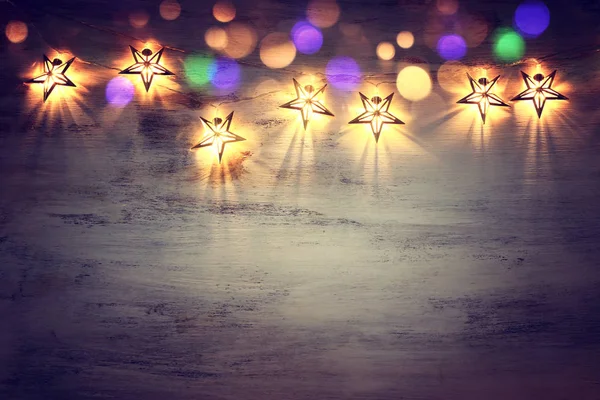 木製の青の背景にクリスマス暖かい金のガーランドライトの休日の概念 — ストック写真
