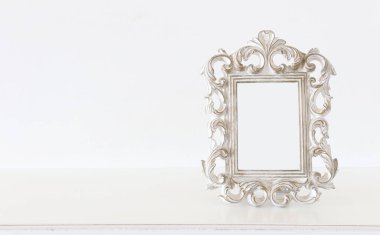 Ahşap masanın üzerinde beyaz barok klasik fotoğraf çerçevesi. Model için, fotoğraf montajı için kullanılabilir