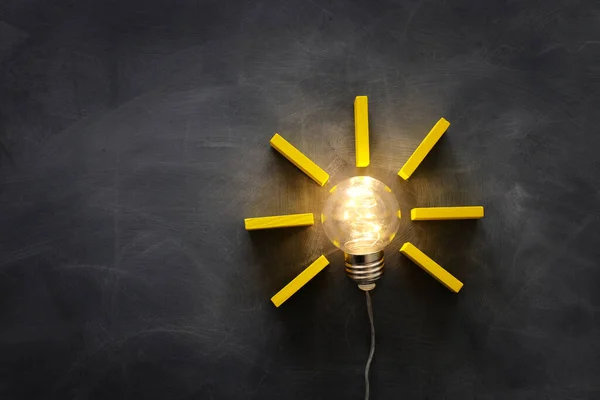 Education concept image. Creative idea and innovation. Light bulb as metaphor over blackboard