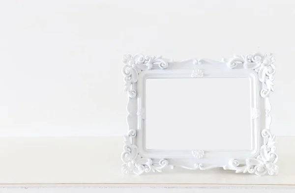 木製のテーブルの上に白いバロック様式のヴィンテージ空の写真フレームのイメージ モックアップのために 写真モンタージュに使用できます — ストック写真
