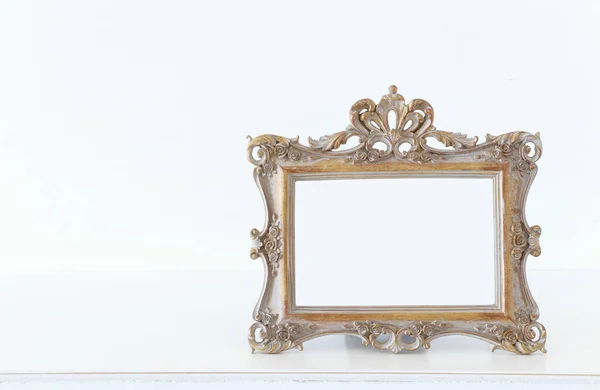 木制桌子上的金色巴洛克老式空相框的图像 模拟时 可用于摄影蒙太奇 — 图库照片