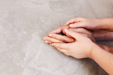 Yaşlı bir adam ve bir çocuğun el ele tutuşması.