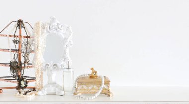 Beyaz eski ayna ve ahşap masanın üzerindeki inciler. Model için, fotoğraf montajı için kullanılabilir