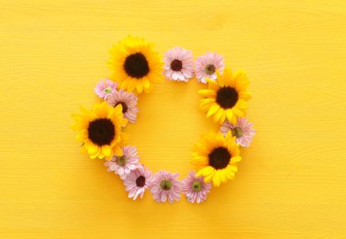 Sarı ahşap zemin üzerinde ayçiçeklerinin üst görünümü