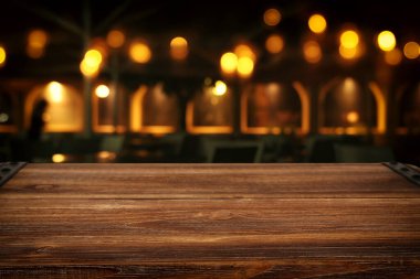Soyut bulanık restoran ışıklarının önündeki ahşap masanın arkaplan resmi