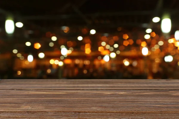 Soyut Bulanık Restoran Işıklarının Önündeki Ahşap Masanın Arkaplan Resmi — Stok fotoğraf