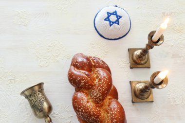 Shabbat görüntüsü. Challah ekmeği, Şabat şarabı ve mumlar. Üst görünüm