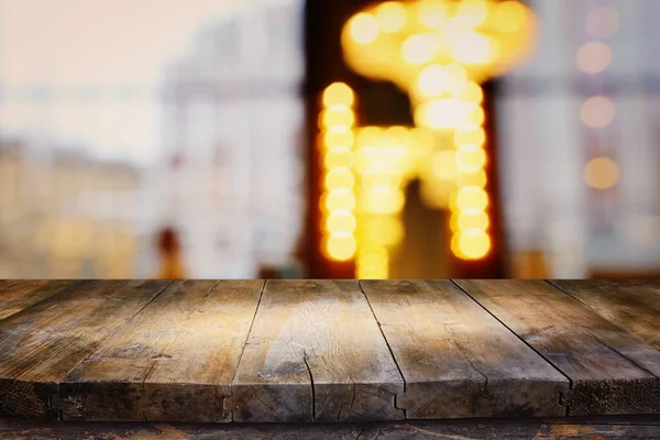 background Image of wooden table in front of abstract blurred restaurant lights