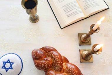 Shabbat görüntüsü. Challah ekmeği, Şabat şarabı ve mumlar. Üst görünüm