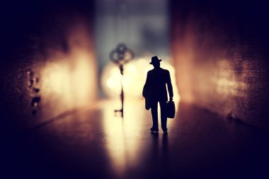 Parlak ışığa doğru yürüyen ve karanlık yolda doğru anahtarı bulan kişinin konsept görüntüsü