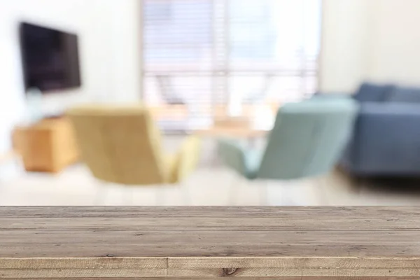 Wooden empty table in front of Living room sofa interior. For product display and presentation