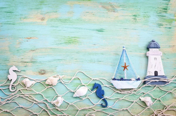 白い装飾の帆のボート 青い木製のテーブルと背景の上の貝殻と航海の概念 — ストック写真
