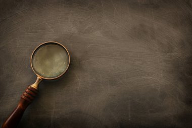 Tahta arka planda tahta saplı klasik büyüteç. Üst görünüm, düz uzanma