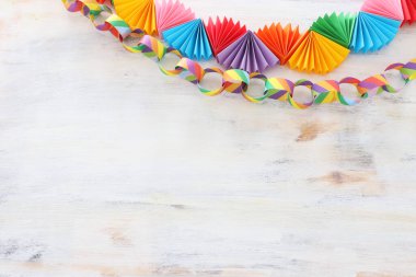 Beyaz ahşap arka planda kağıt renkli zincir çelenkler. Geleneksel Yahudi sukkot bayram dekorasyonu