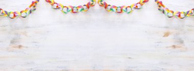 Paper colorful chain garland over white wooden background. Traditional jewish sukkot holiday decoration clipart