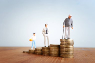 Emeklilik planı fikri, bozuk para yığınının üzerinde duran kıdemli adam.
