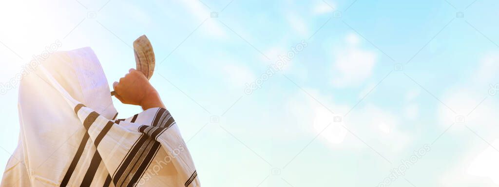 Jewish man blowing the Shofar (horn) of Rosh Hashanah (New Year). Religious symbol.