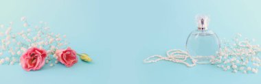 Mavi pastel arka planda zarif bir parfüm şişesi resmi