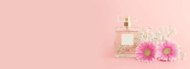 Pembe pastel arka planda zarif bir parfüm şişesi resmi